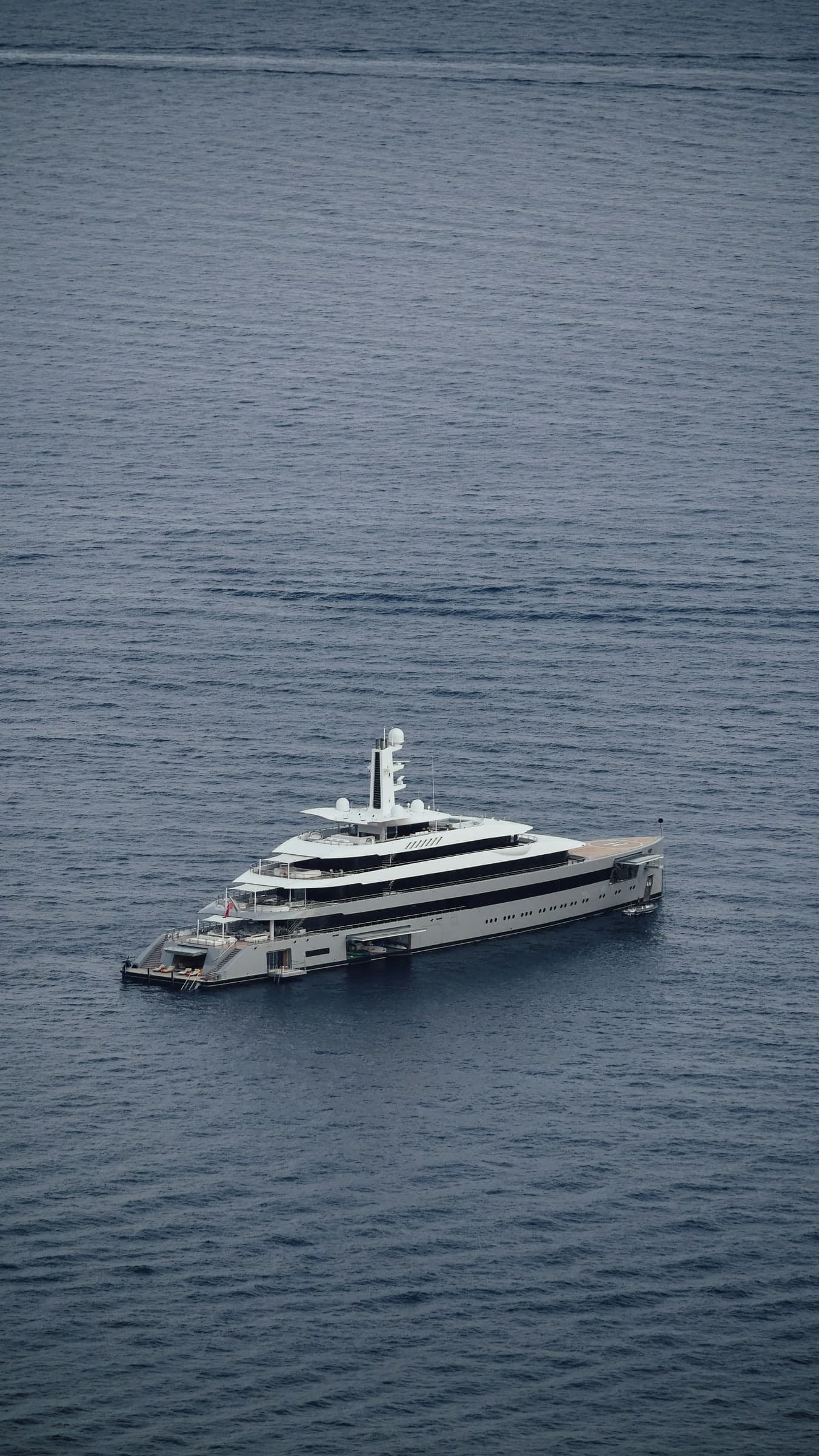 A white yacht alone on a pale, calm sea