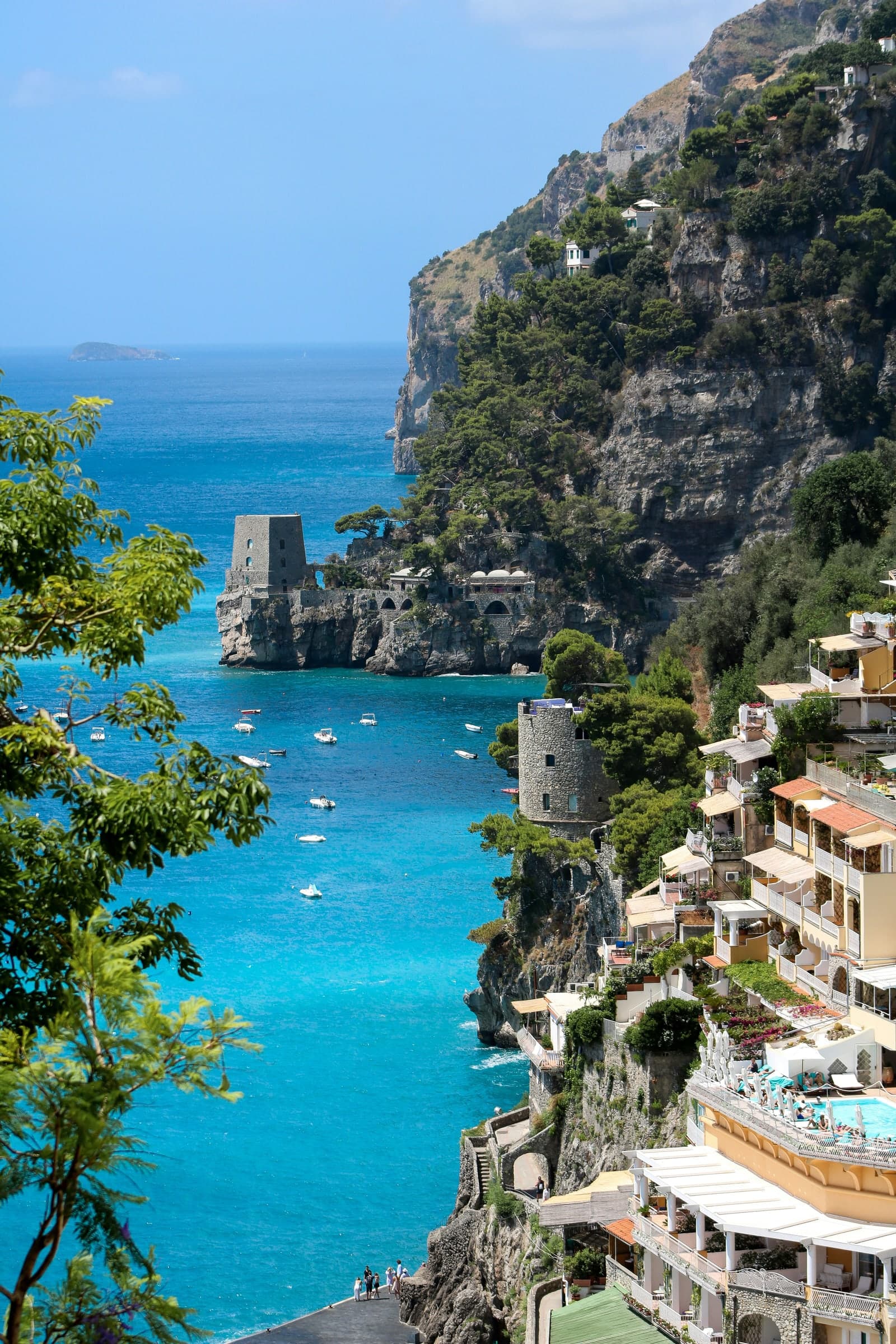 A cliffside town above a turquoise bay