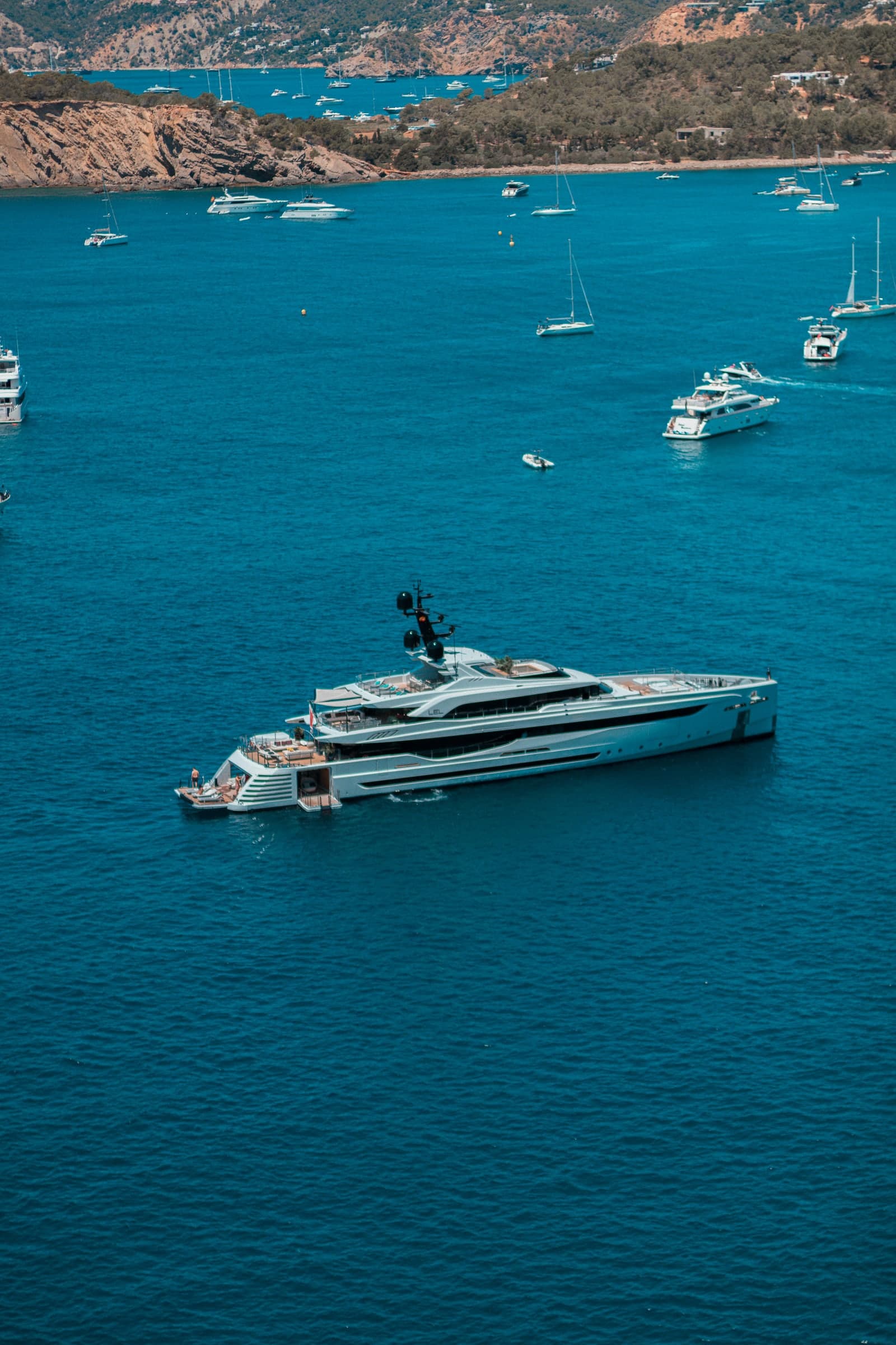 A yacht at anchor in a blue bay, from above
