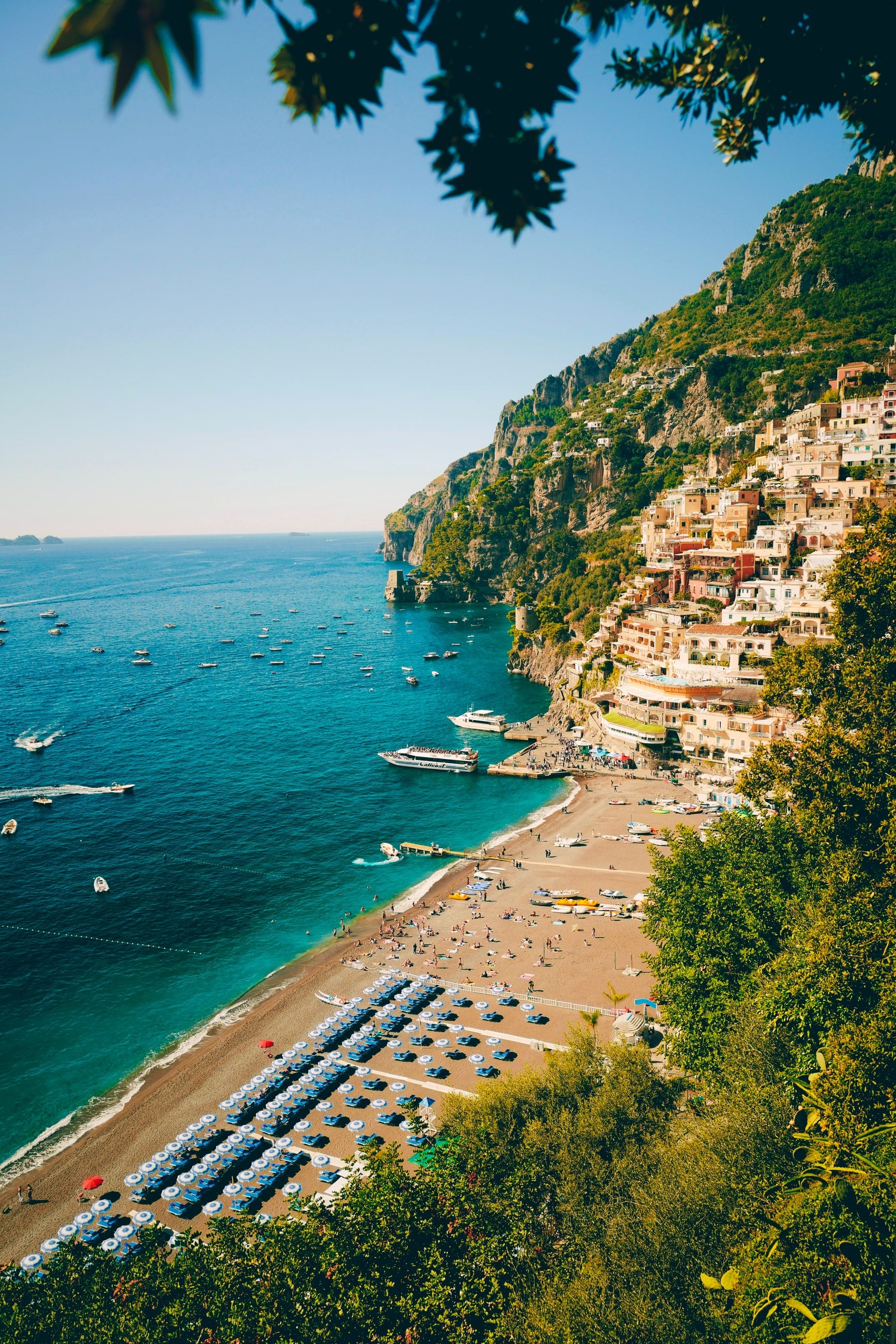 A hillside town above a green coast, seen from the sea
